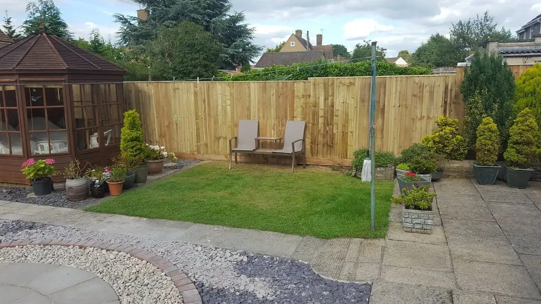 A finished garden with new timber fencing, a paved patio and neat lawn